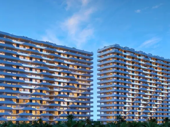 Fachada nocturna de See Towers Cancún, dos torres residenciales iluminadas sobre Blvd. Colosio, Quintana Roo.